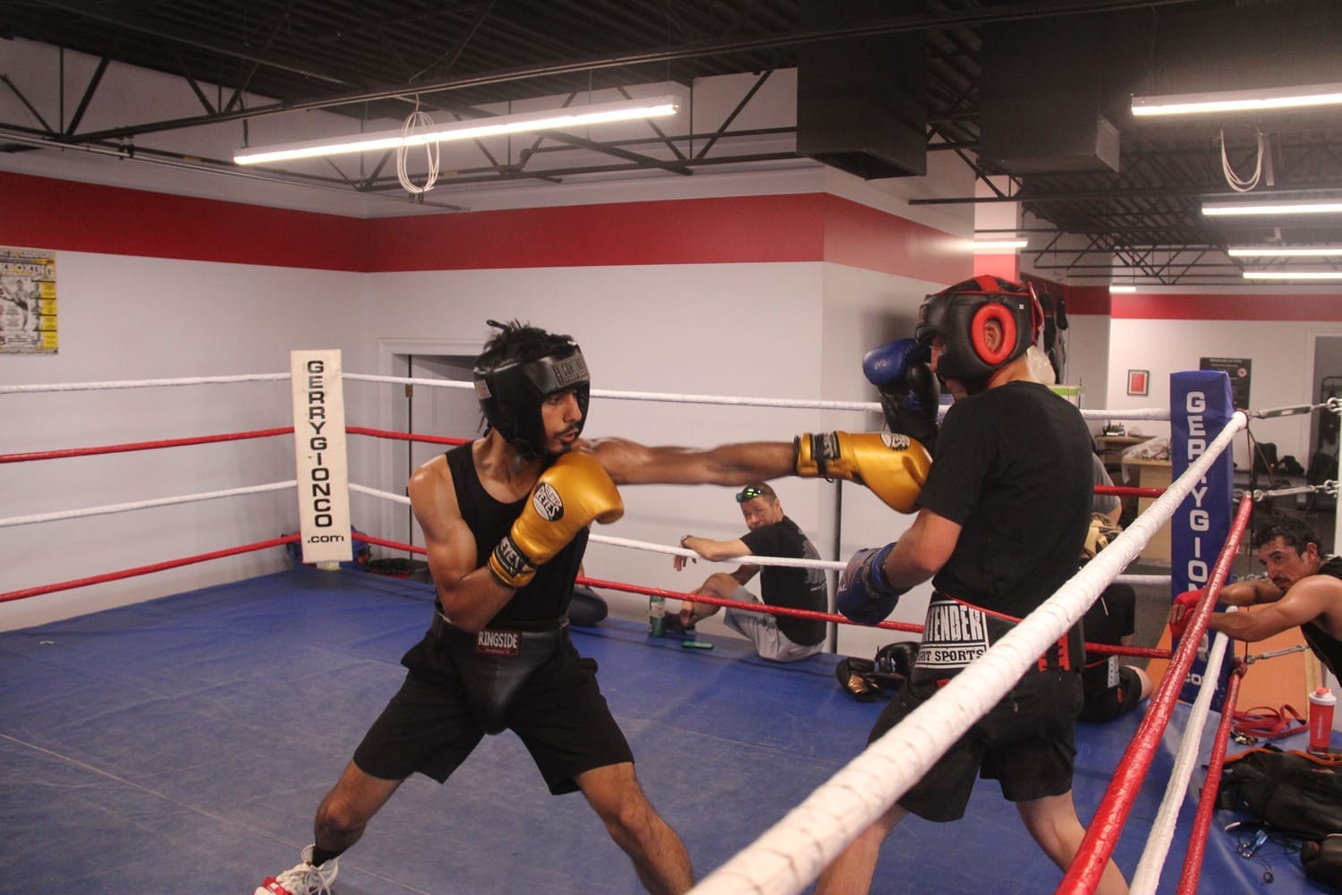 A student practices a jab with a coach during boxing training